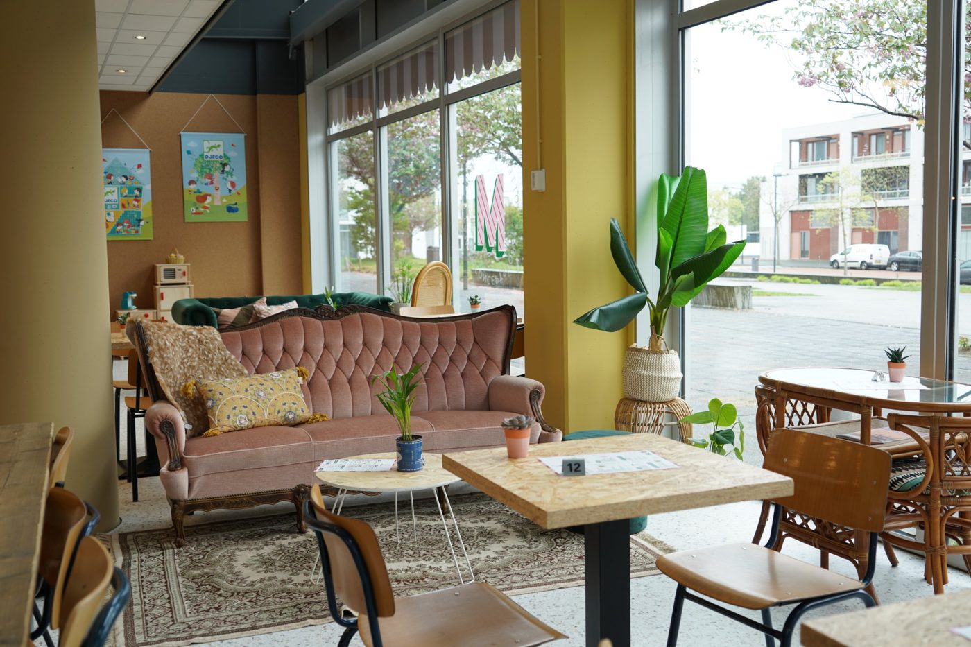 Lounge met roze bank en grote ramen