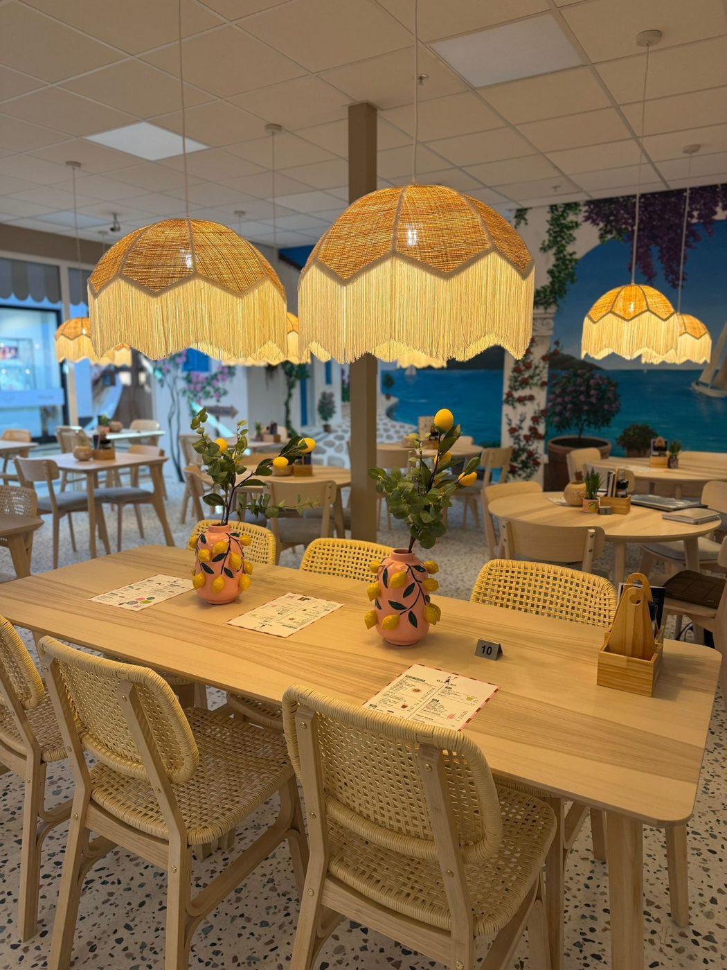 Tafel met citroenvazen onder rieten lampen